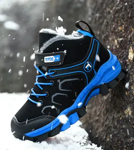 Detail of children's blue and black winter hiking boot with warm fleece lining in snow