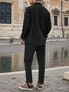Rear view of a man wearing a black corduroy shirt and matching trousers set