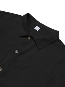 Detailed close-up view of black corduroy shirt collar with size M polyester label