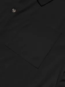 Detailed macro view of a black corduroy men shirt showing the chest pocket and texture