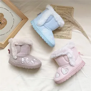 Detail view of girl's warm embroidered snow boots with faux fur lining and bows