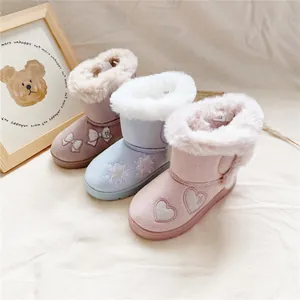 Detail view of plush children's snow boots in pink, blue, and brown with embroidery