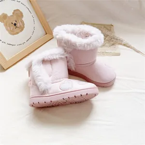 Close-up of pink girls' snow boots with fur lining and heart embroidery details.
