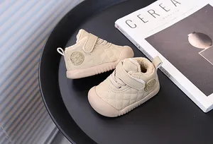 Cozy beige fleece-lined toddler walking shoes with star detail on a minimalist black tray.