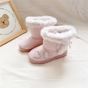 Close-up of pink girl's snow boots with heart embroidery and white faux fur trim.