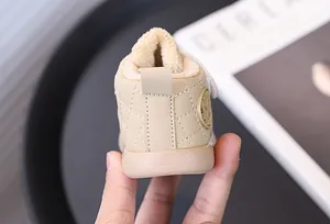 Close-up of warm beige fleece-lined baby walking shoes with soft quilted pattern