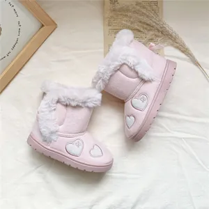 Close-up of pink girl's snow boots with white fur trim and heart embroidery details