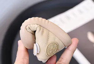 Close-up showing the soft and flexible sole of beige fleece-lined toddler walker shoes.