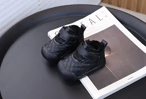 Close-up of warm black quilted baby walking shoes featuring soft fleece lining and velcro