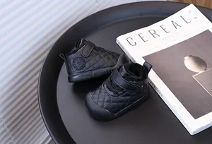 Detail of black quilted baby walking shoes with warm lining and soft non-slip sole.