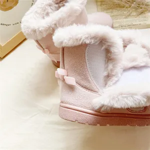 Close-up of pink girls' snow boots with thick faux fur lining and bow detail.