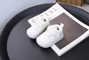 Detailed view of white quilted baby walking shoes with warm plush lining and velcro strap