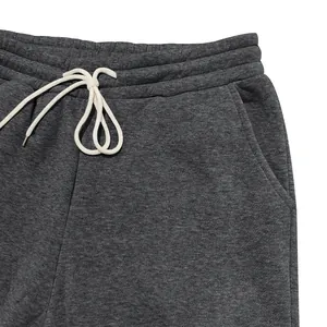 Detail der Taille einer dunkelgrauen Fleecehose mit weißem Kordelzug und Tasche