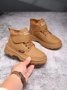 Gros plan détaillé sur des bottes d'hiver marron pour enfants avec doublure en peluche.