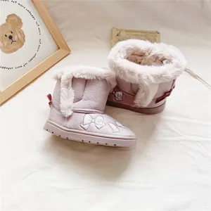 Close-up of pink girl's winter snow boots with plush fur lining and bow embroidery
