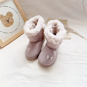 Detail view of pink girl's snow boots featuring thick fur lining and embroidered bow