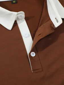 Macro view of men's brown Polo shirt showing white collar detail and button placket
