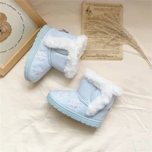 Macro view of light blue children's winter boots with star embroidery and fur trim.
