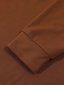 Close-up detail of a brown long-sleeved polo shirt cuff showing fine fabric texture