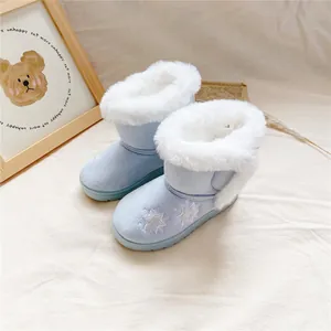 Detail of blue girls snow boots with star embroidery and white faux fur lining.