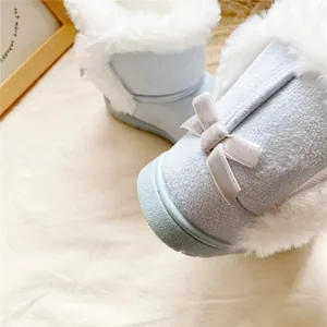 Close-up of light blue children's snow boots with fluffy faux fur and a cute bow