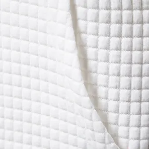 Vista macro dettagliata della trama del tessuto bianco trapuntato per abiti da uomo