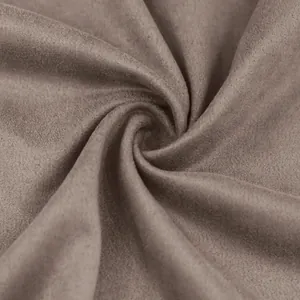 Détail macro d'un tissu en faux suède marron montrant sa texture douce et son drapé