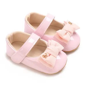 Nahaufnahme rosa Baby-Mary-Jane-Schuhe mit Stoffschleife und glänzendem Lack-PU-Finish