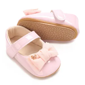 Detail von rosa Baby-Mary-Janes aus Lackleder mit Stoffschleife und weicher Sohle