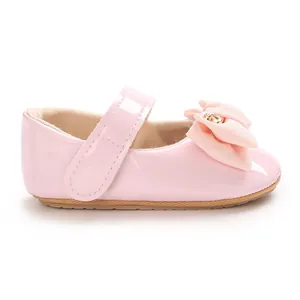 Detailansicht rosa Baby-Mary-Janes aus Lackleder mit Schleife und goldener Schnalle.