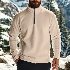 Detail van de beige heren fleece trui met kwart rits in een winters berglandschap