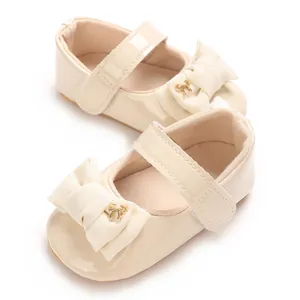 Detail von cremefarbenen Baby-Mary-Janes mit großer Schleife und weicher PU-Sohle