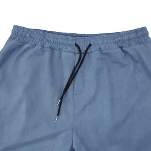 Détail d'un pantalon en daim bleu avec taille élastique et cordon de serrage pour homme
