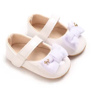Detailansicht weißer Baby-Mary-Jane-Schuhe mit großen Stoffschleifen und Goldakzenten