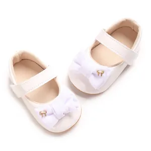 Detailansicht der weißen Baby-Mary-Janes mit lilafarbener Schleife und Goldakzent