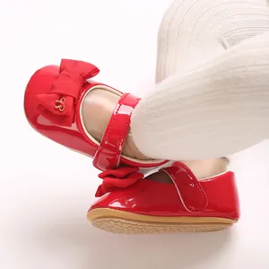 Nahaufnahme der roten glänzenden PU-Leder Baby Mary Jane Schuhe mit dekorativer Schleife