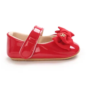 Detailaufnahme eines roten Lackleder-Babyschuhs Mary Jane mit einer großen Schleife.