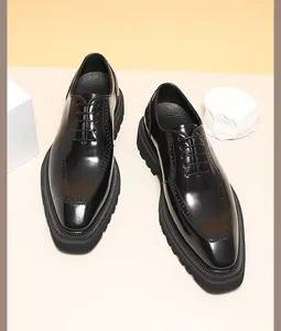 Top-down view of glossy black leather men's Oxford shoes with brogue detailing and thick soles