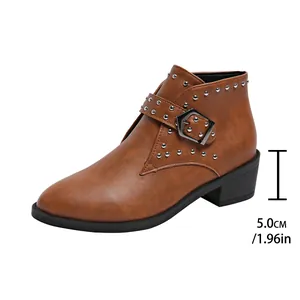Detail van de bruine enkellaars met klinknagels en 5 cm blokhakhoogte