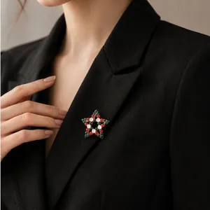 Elegante Weihnachts-Sternbrosche mit roten und grünen Strasssteinen auf einem Blazer