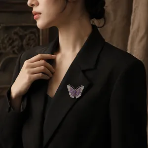 Elegante spilla a farfalla in cristallo viola e argento sul risvolto di un blazer nero