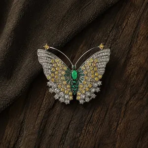 Dettaglio squisito di un'elegante spilla a farfalla con gemme verdi, gialle e bianche.
