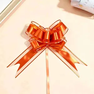 Macro detail of a large matte metallic orange snow gauze pull bow for gift wrap decoration
