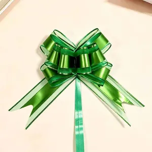 Detailed view of a large green metallic snow yarn pull bow for festive gift wrapping