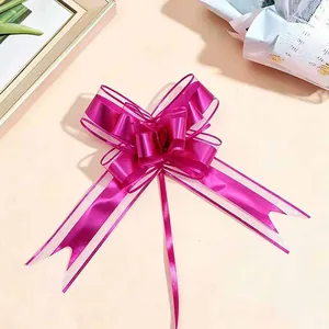 Detail view of the large magenta metallic matte ribbon bow with snow yarn edges.