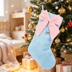 Nahaufnahme eines hellblauen Plüsch-Weihnachtssockens mit großer rosa Schleife und Glocke