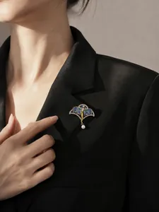 Nahaufnahme einer Vintage-Emaille-Feenbrosche mit Flügeln und Perle an einem schwarzen Blazer