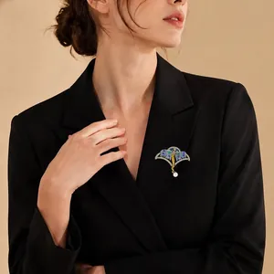 Vintage-Emaille-Feenbrosche mit glasierten Flügeln und Perle auf elegantem schwarzem Blazer