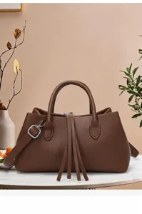 Detailed view of vintage brown leather tote bag with elegant tassel and silver hardware