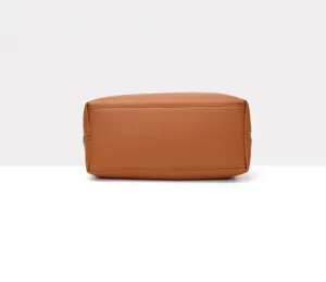 Bottom view of a textured brown faux leather tote bag showing stitching details